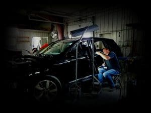 Technician working on black SUV performing paintless dent repair