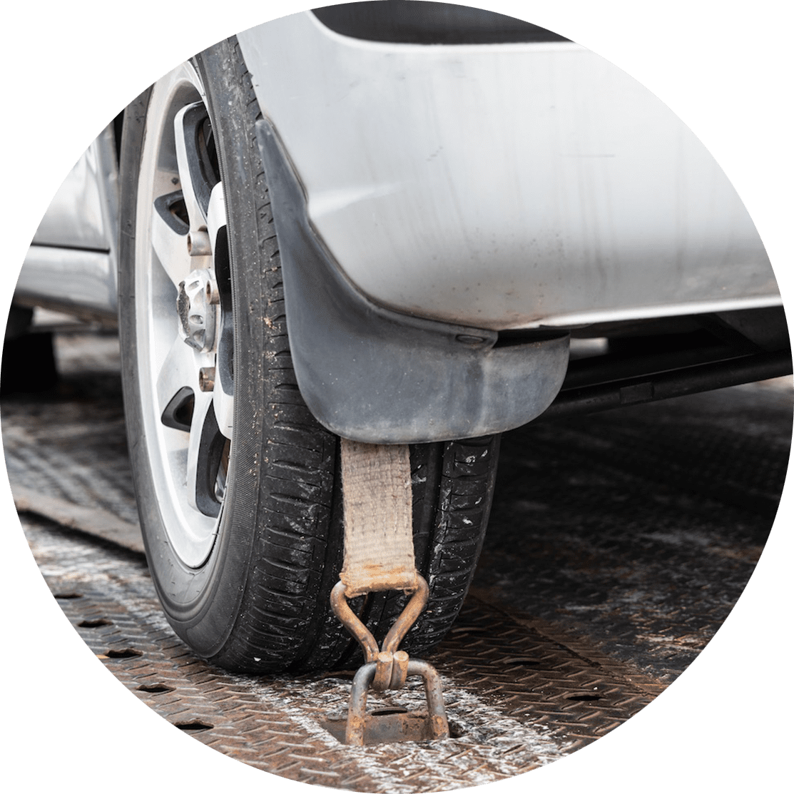 Close-up of car wheel tied with safety harness on flatbed tow truck